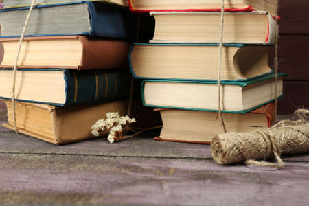 Stacks of books with dry flowers and twine on table close upの写真素材