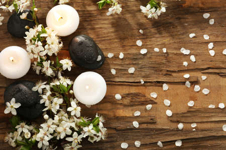 Spa stones with candles and spring flowers on table close upの写真素材