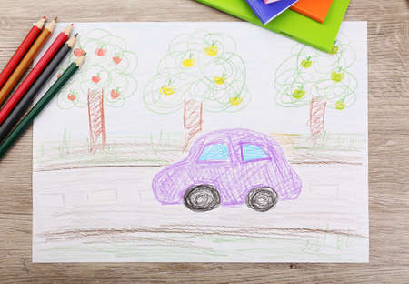 Kids drawing on white sheet of paper with crayons, closeupの写真素材