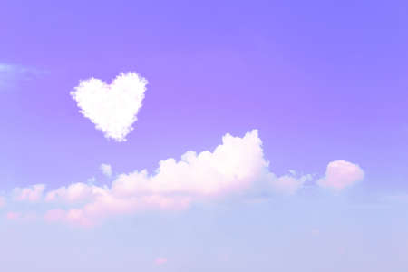Violet sky background with clouds in heart shapeの写真素材