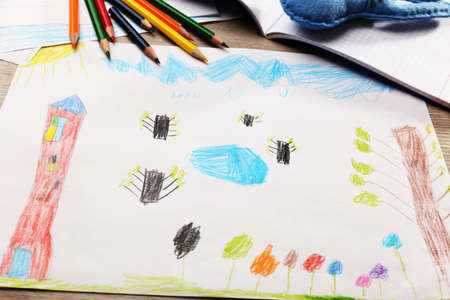 Kids drawing on white sheet of paper with crayons, closeupの写真素材