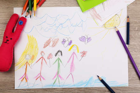 Kids drawing on white sheet of paper with crayon,closeupの写真素材