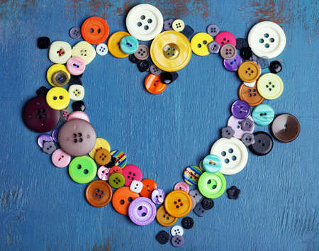 Sewing buttons heart on wooden backgroundの写真素材