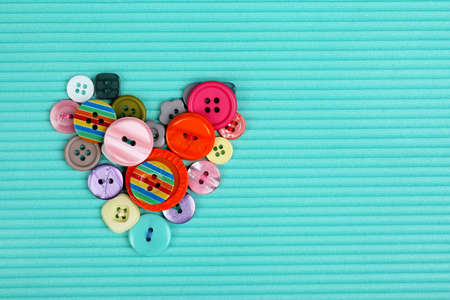 Sewing buttons heart on cloth backgroundの写真素材