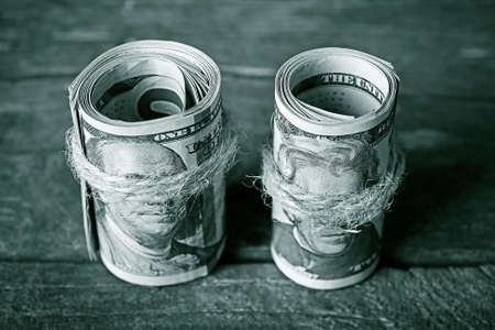 Dollars roll on wooden backgroundの写真素材