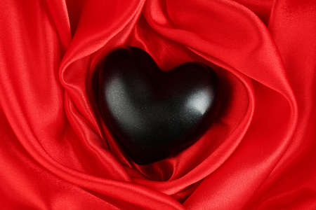 Black heart on fabric backgroundの写真素材