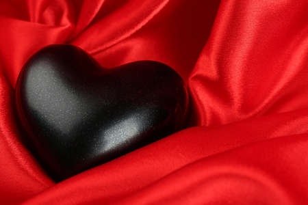 Black heart on fabric backgroundの写真素材