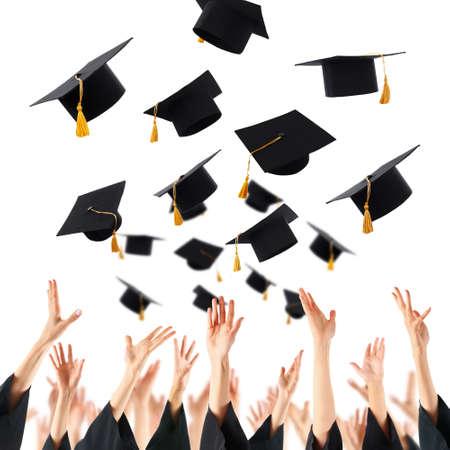 Graduates hands throwing graduation hats , isolated on whiteの写真素材