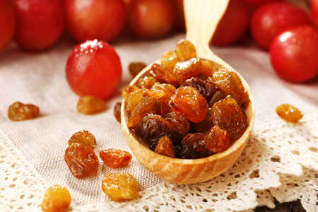 Raisins in wooden spoon with grapes on table close upの写真素材