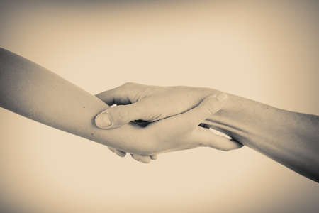 Two hands reaching toward each other. Helping concept. Vintage toneの写真素材