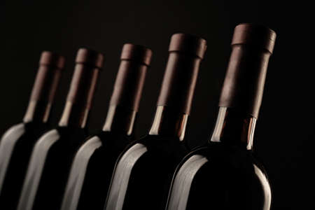 Different wine bottlenecks on dark backgroundの写真素材