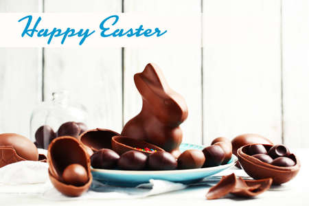 Chocolate Easter eggs and rabbit on white wooden backgroundの写真素材