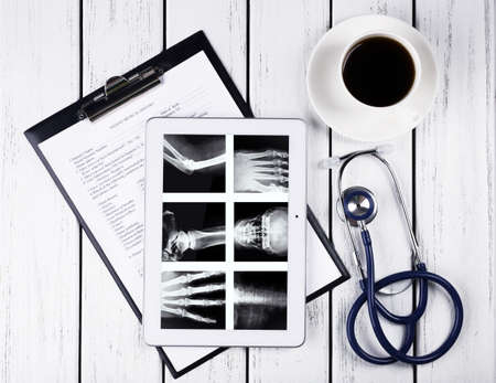 Medical tablet with stethoscope on table backgroundの写真素材