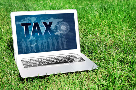 Online Tax payment concept. Laptop on green lawnの写真素材