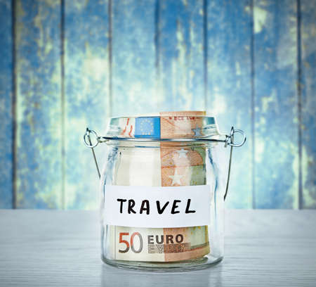 Jar for savings full of coins wooden backgroundの写真素材