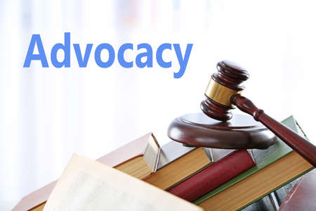 Gavel with pile of books on light blurred backgroundの写真素材