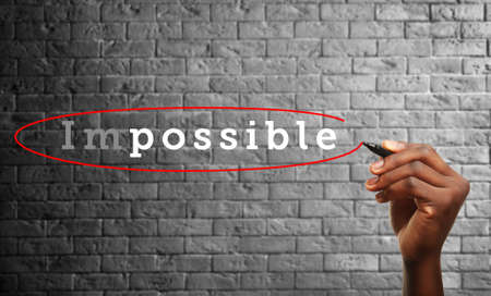 Human hand turning word impossible into possibleの写真素材