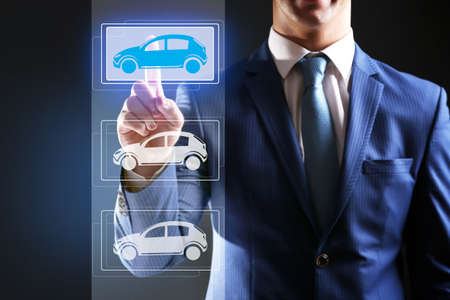 Businessman touching icon of car on virtual screenの写真素材