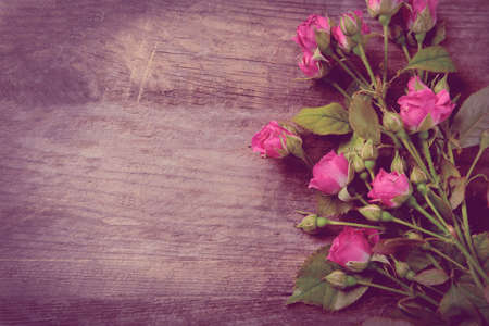 Beautiful bouquet of pink little roses on wooden background, copy spaceの写真素材
