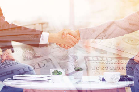 Business handshake on dollars backgroundの写真素材