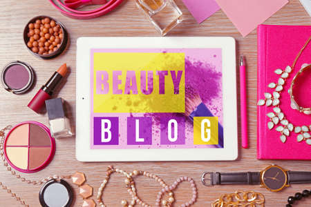Tablet and different female items on wooden table, top view. Beauty blog conceptの写真素材