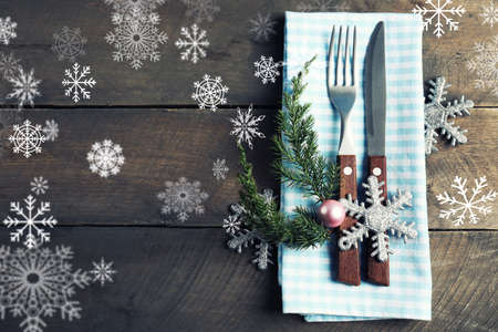Christmas serving cutlery with napkin on a wooden background. Snow effectの写真素材
