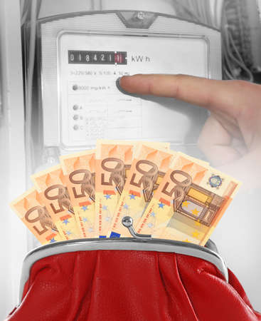 Red purse with euro banknotes and male finger pointing on electric meter display.の写真素材