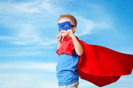 Superhero kid on blue sky backgroundの写真素材