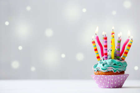Delicious birthday cupcake on light backgroundの写真素材