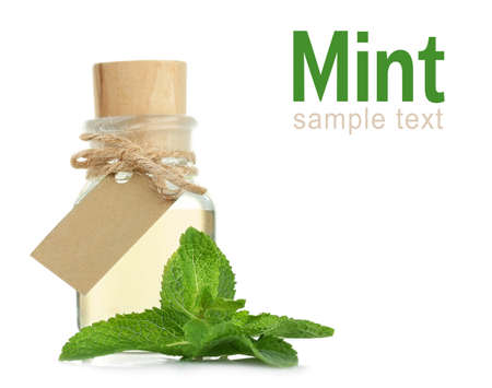 Glass bottle of essential oil, closeup. Word MINT on white background. Spa beauty concept.の写真素材