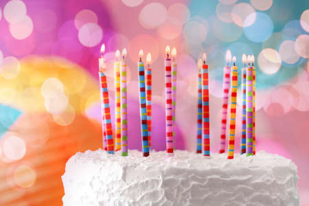 Lighted candles on birthday cake, closeupの写真素材