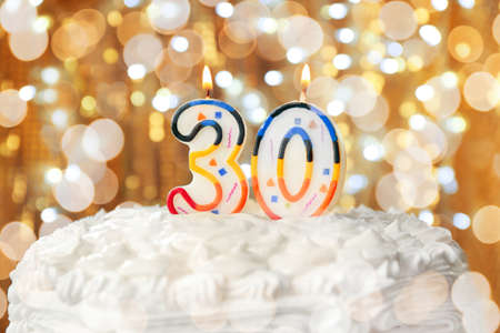 Lighted candles on birthday cake, closeupの写真素材