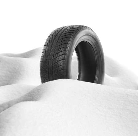 Car tire in snowdrift on white background. Winter tires concept.の写真素材