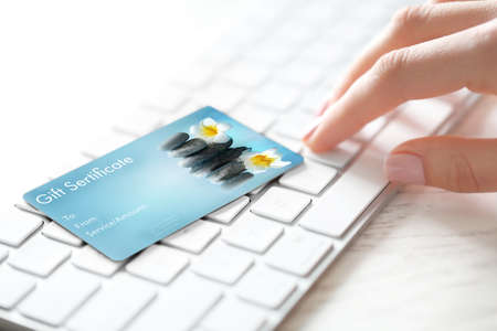 Holiday celebration concept. Spa service gift certificate on keyboardの写真素材