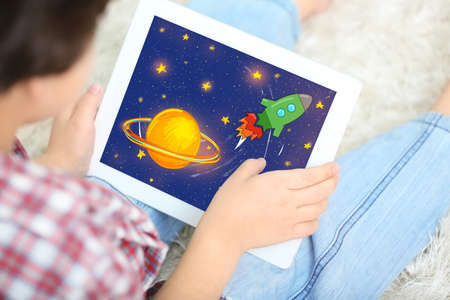 Little boy drawing on tablet at homeの写真素材