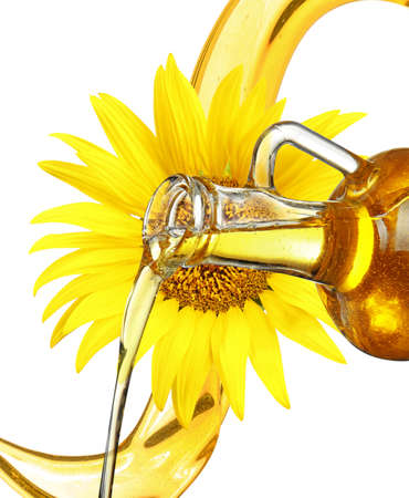 Pouring cooking oil from glass jug and sunflower on backgroundの写真素材