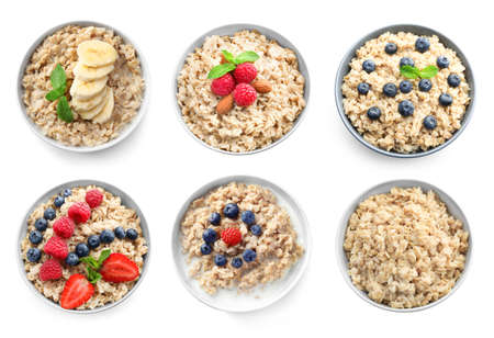 Bowls of oatmeal with berries and fruits on white backgroundの写真素材