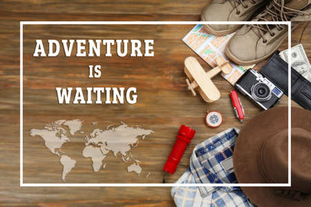 Text ADVENTURE IS WAITING and travel stuff on wooden backgroundの写真素材