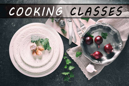 Cooking classes concept. Cutlery with dishware and vegetables on gray backgroundの写真素材