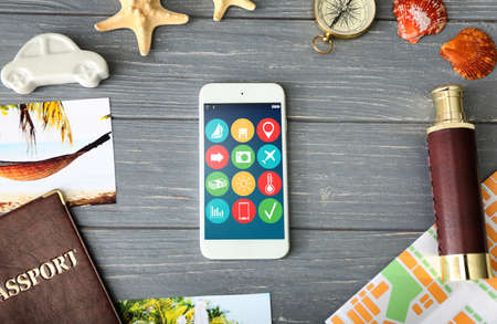 Modern technology and tourism, travel apps concept. Smartphone on wooden backgroundの写真素材