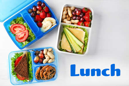 Concept of school lunch. Lunchboxes and food on wooden backgroundの写真素材