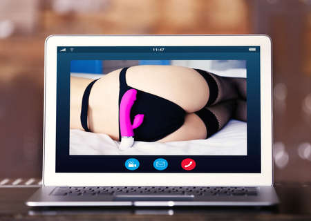 Virtual sex concept. Video chat with woman on laptopの写真素材