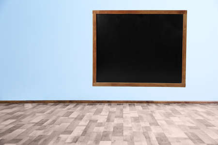 Blank blackboard on color wall in empty class roomの写真素材