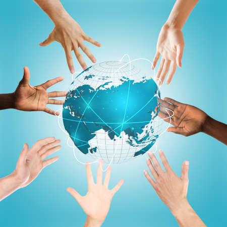 Hands surrounding globe on blue background. Concept of worldwide unity and environment protectionの写真素材