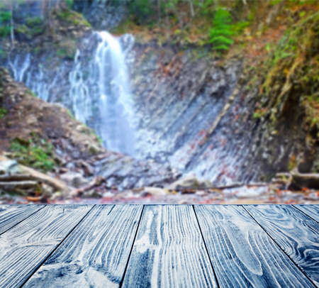 Wooden table and waterfall on backgroundの写真素材