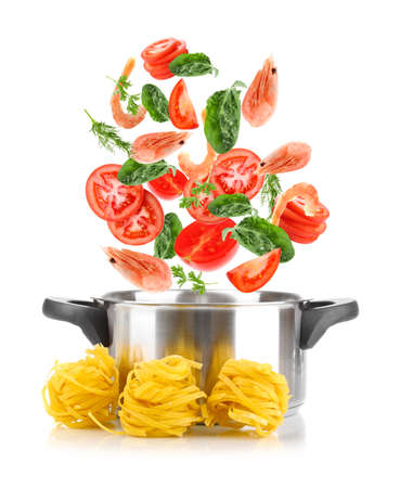 Ingredients falling into saucepan on white background. Tasty pasta recipeの写真素材