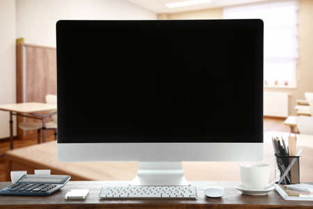 Modern computer with blank screen on table in classroomの写真素材