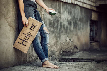 Poverty concept. Poor woman begging for help and money on streetの写真素材