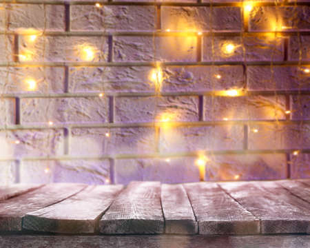 Wooden table and Christmas lights on backgroundの写真素材