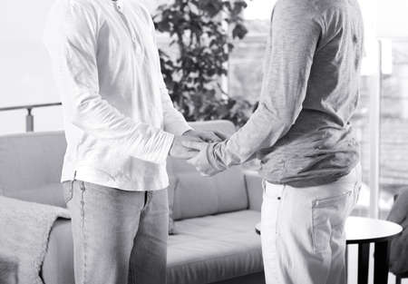 Gay couple holding hands together at home. LGBT rights conceptの写真素材